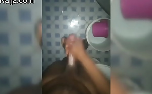 A guy wanking his dick in a bathroom