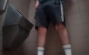 Young guy peeing in a public toilet